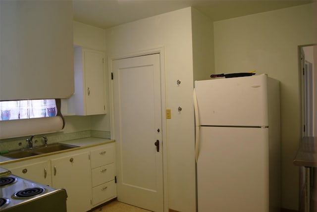 kitchen featuring white cabinetry, sink, and white appliances