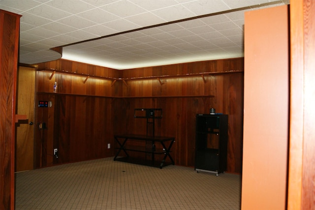 hallway with light colored carpet and wood walls