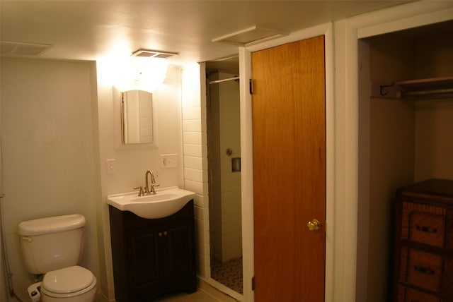 bathroom with vanity, toilet, and a shower