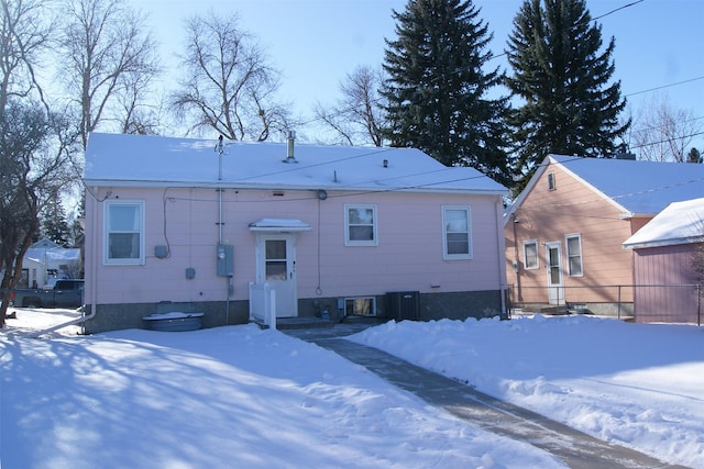 snow covered house with central AC