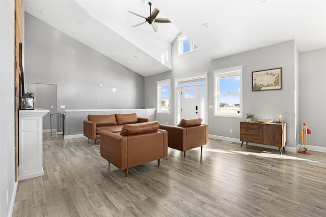 living room with light hardwood / wood-style flooring, high vaulted ceiling, and ceiling fan