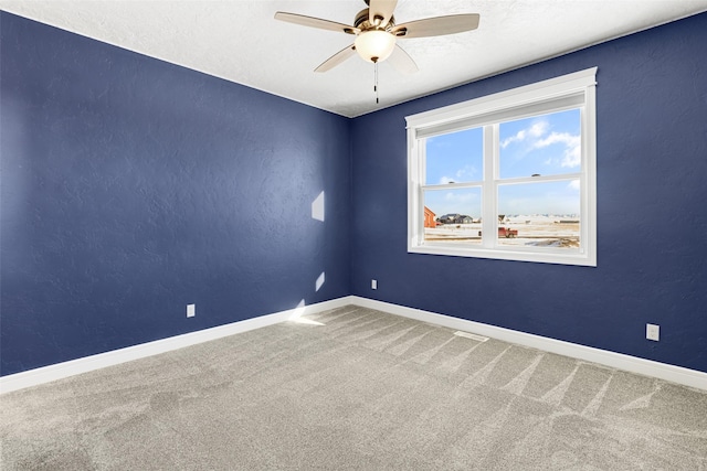 carpeted spare room featuring ceiling fan and a textured ceiling