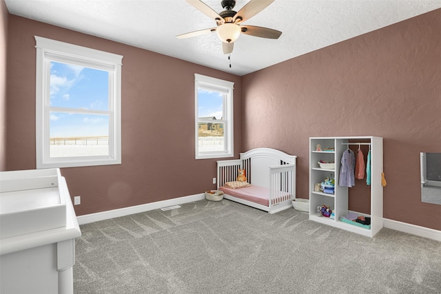 game room with a textured ceiling, ceiling fan, and carpet