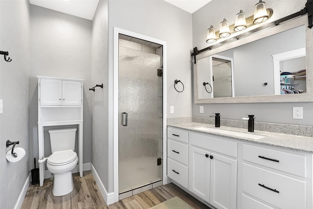 bathroom featuring an enclosed shower, vanity, wood-type flooring, and toilet