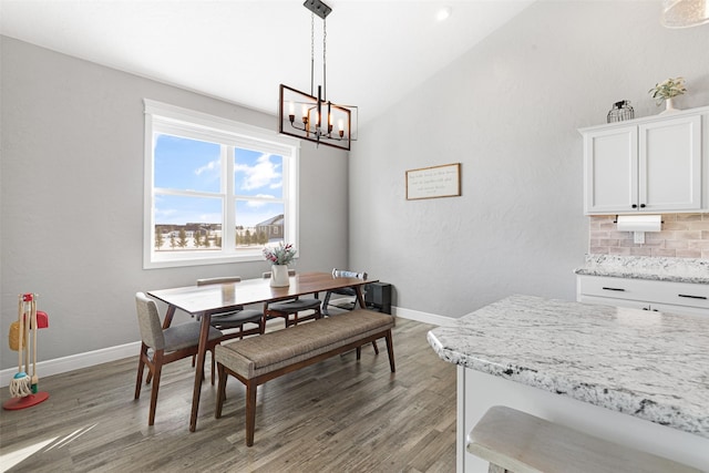 dining room with hardwood / wood-style flooring and a chandelier