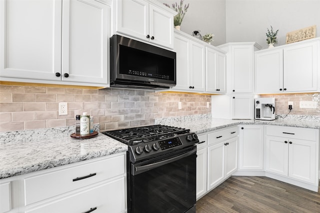 kitchen with dark wood-type flooring, stainless steel gas range, light stone countertops, white cabinets, and decorative backsplash