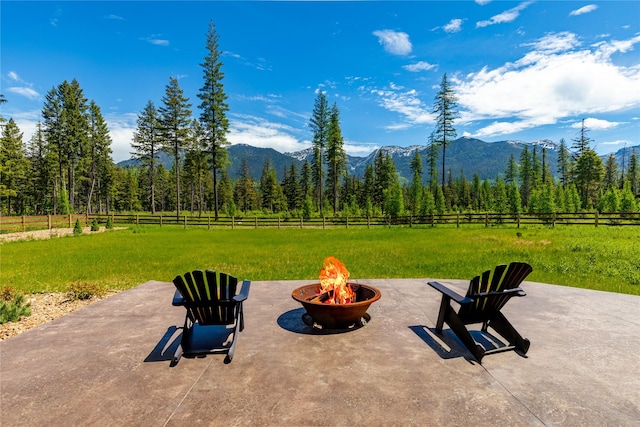 3900 Foothill Rd, Kalispell, MT 59901 - view of patio / terrace with an outdoor fire pit, a mountain view, and a view of trees