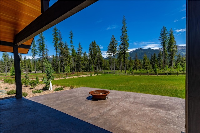 3900 Foothill Rd, Kalispell, MT 59901 - view of patio / terrace featuring an outdoor fire pit, a forest view, and a mountain view