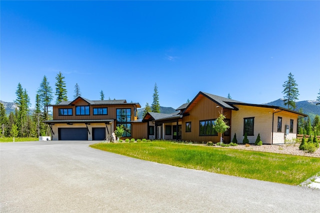 3900 Foothill Rd, Kalispell, MT 59901 - view of front facade featuring driveway, a mountain view, a front yard, and a garage