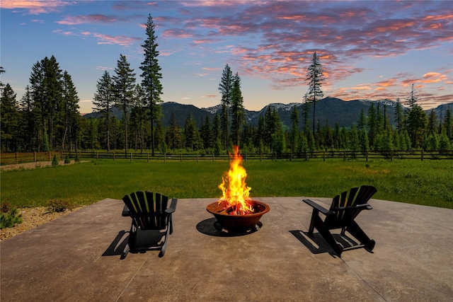 3900 Foothill Rd, Kalispell, MT 59901 - patio terrace at dusk with an outdoor fire pit, a patio area, and a mountain view