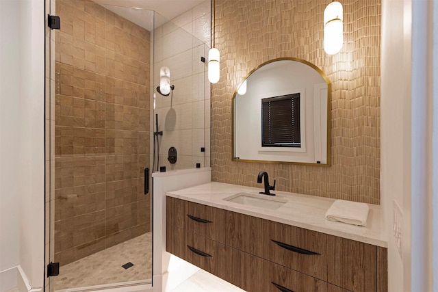 bathroom featuring a shower with door and vanity