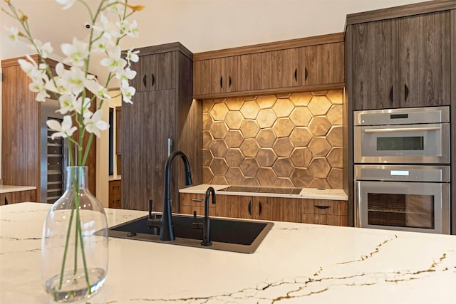3900 Foothill Rd, Kalispell, MT 59901 - kitchen with stainless steel double oven, tasteful backsplash, a sink, black electric stovetop, and light stone counters