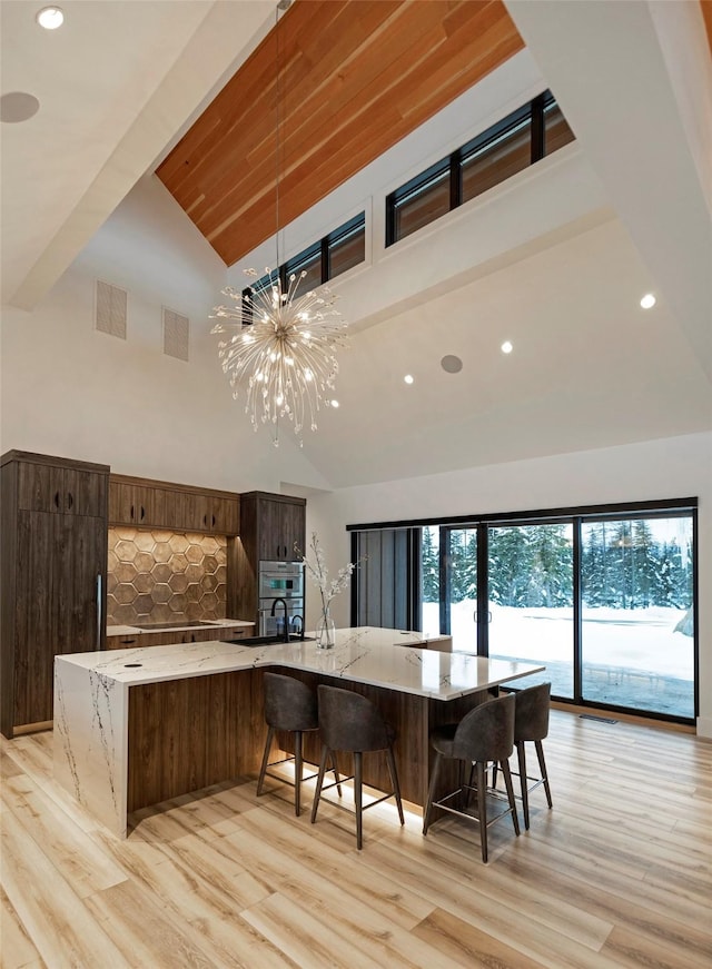 3900 Foothill Rd, Kalispell, MT 59901 - kitchen featuring high vaulted ceiling, light wood-style flooring, light stone countertops, recessed lighting, and a large island