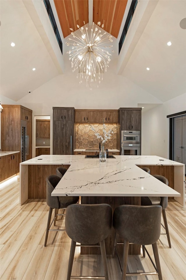 3900 Foothill Rd, Kalispell, MT 59901 - dining space featuring light wood-style floors, beam ceiling, high vaulted ceiling, recessed lighting, and a chandelier