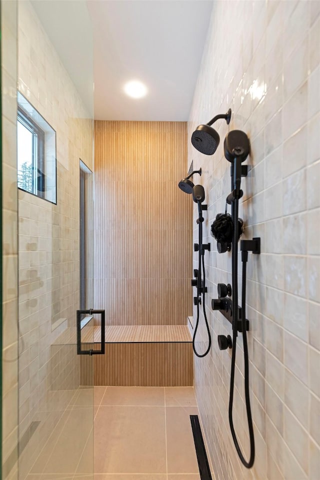 bathroom featuring tiled shower and tile patterned flooring