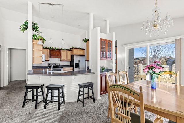 kitchen featuring a breakfast bar, kitchen peninsula, stainless steel fridge with ice dispenser, and light carpet