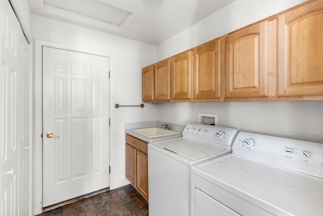 washroom with cabinets, washer and clothes dryer, and sink