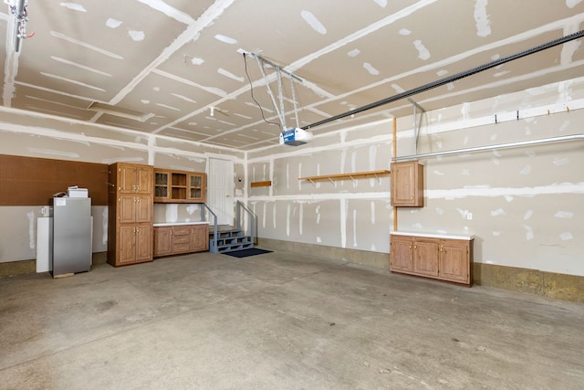 garage featuring a garage door opener and stainless steel fridge