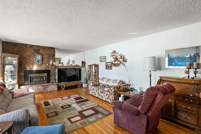 living room featuring hardwood / wood-style flooring, a fireplace, and a textured ceiling