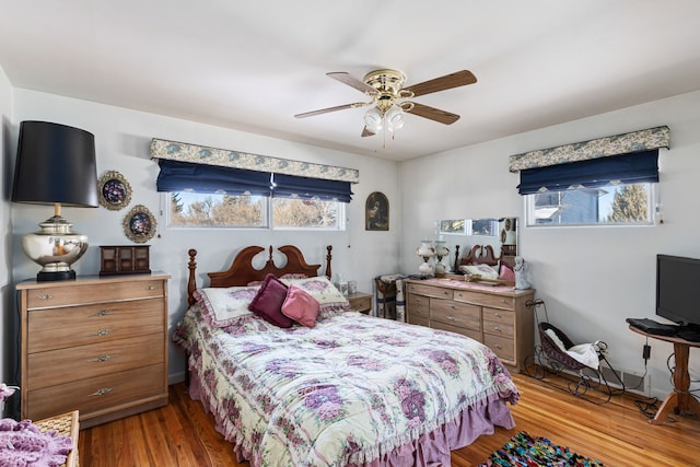 bedroom featuring multiple windows, hardwood / wood-style flooring, and ceiling fan