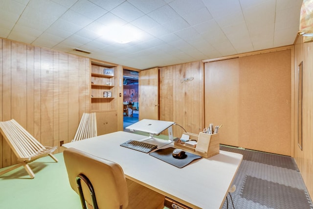 office space with wooden walls and carpet floors