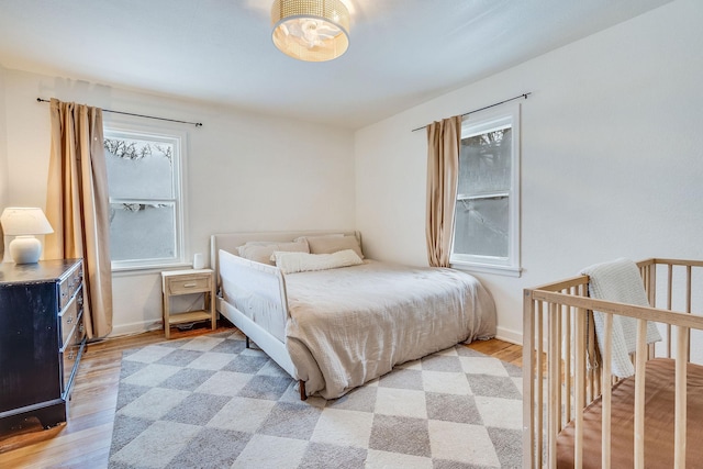 bedroom featuring multiple windows and light hardwood / wood-style flooring