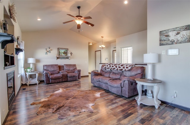 living room with a fireplace, ceiling fan with notable chandelier, dark wood-type flooring, and high vaulted ceiling