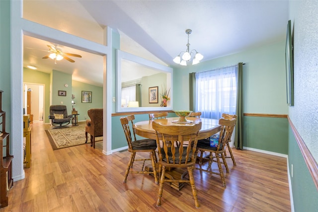 dining room featuring lofted ceiling, wood-type flooring, and a notable chandelier