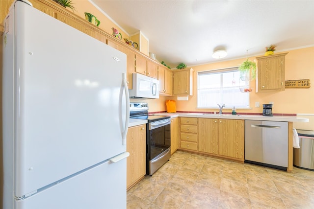 kitchen with appliances with stainless steel finishes, sink, and light brown cabinets