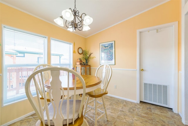 dining room with an inviting chandelier, ornamental molding, and a healthy amount of sunlight