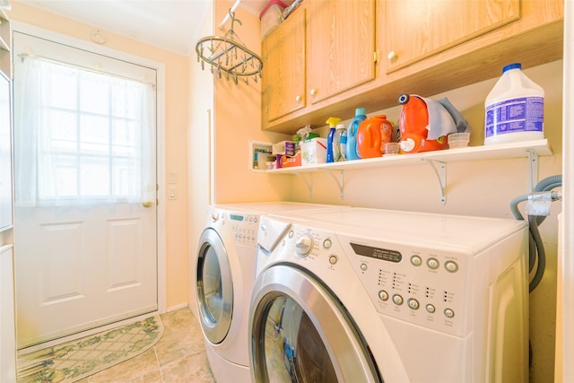 laundry room featuring cabinets, light tile patterned floors, and washing machine and clothes dryer