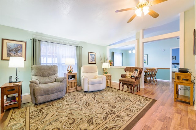 living room with lofted ceiling, wood-type flooring, and ceiling fan