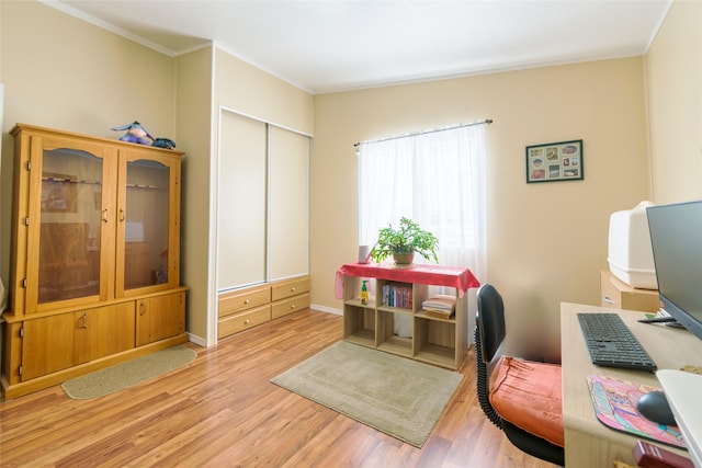 office area with crown molding and light wood-type flooring