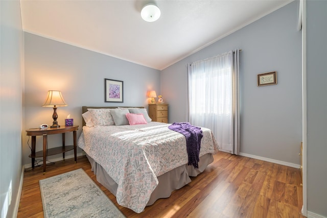 bedroom featuring hardwood / wood-style flooring and lofted ceiling