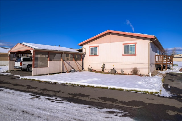 exterior space featuring a carport and a sunroom