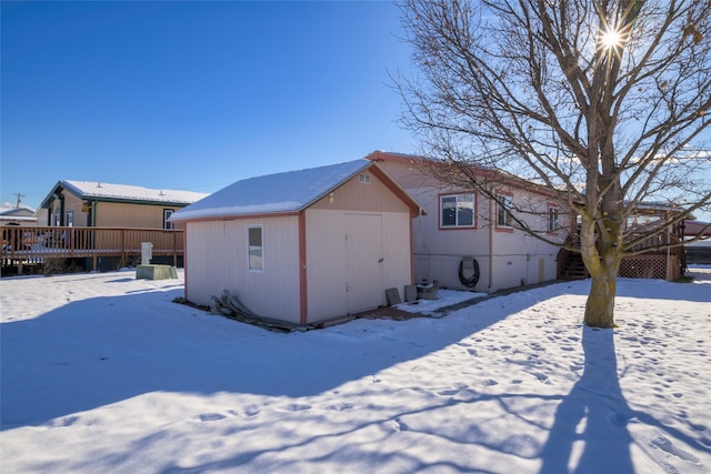 snow covered property with a shed