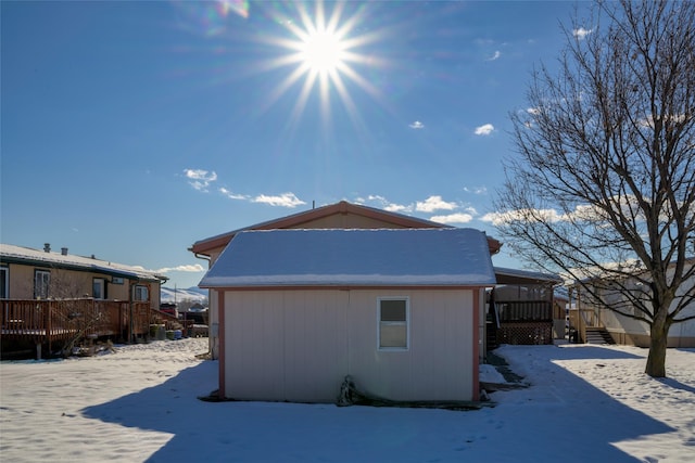 snow covered house with a wooden deck