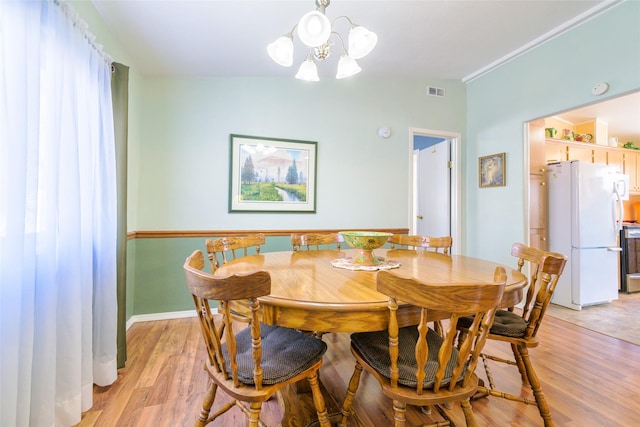 dining room featuring a chandelier and light hardwood / wood-style flooring