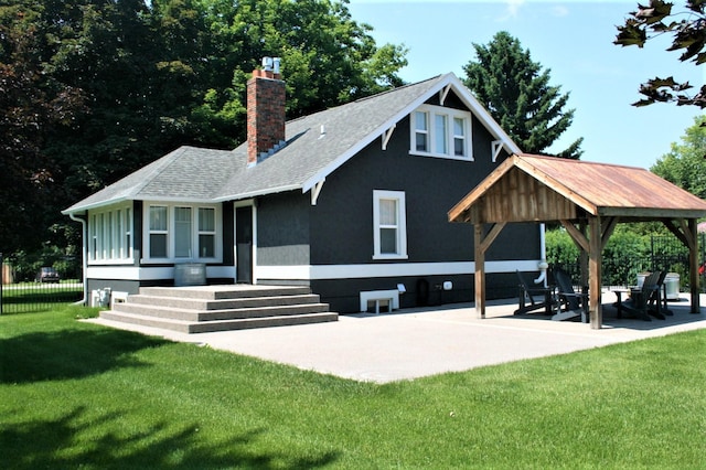 back of property featuring a patio area and a lawn