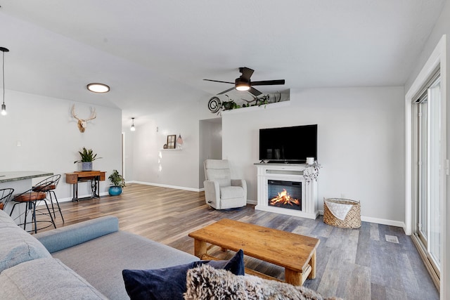 living room with hardwood / wood-style flooring, lofted ceiling, and ceiling fan