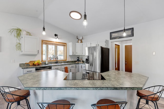 kitchen featuring appliances with stainless steel finishes, a breakfast bar, and white cabinets