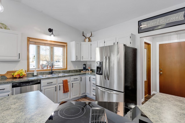 kitchen with white cabinetry, appliances with stainless steel finishes, sink, and lofted ceiling