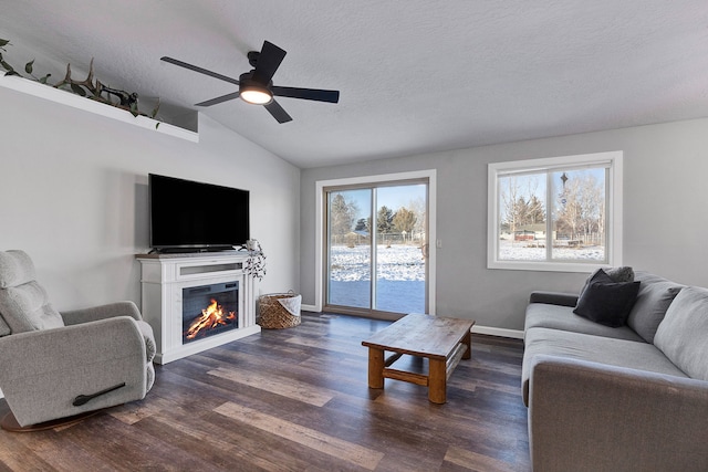 living room featuring lofted ceiling, ceiling fan, dark hardwood / wood-style floors, and a textured ceiling