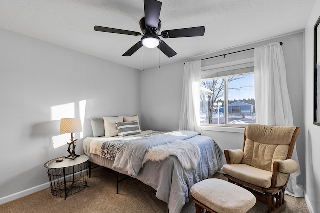 bedroom with ceiling fan, carpet, and a textured ceiling