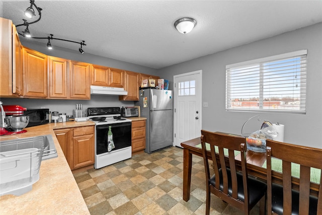 kitchen featuring sink, range with electric cooktop, stainless steel refrigerator, and a textured ceiling