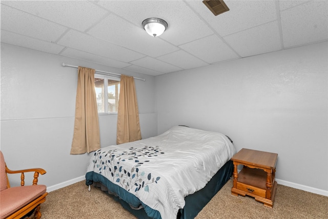 bedroom with a drop ceiling and carpet floors