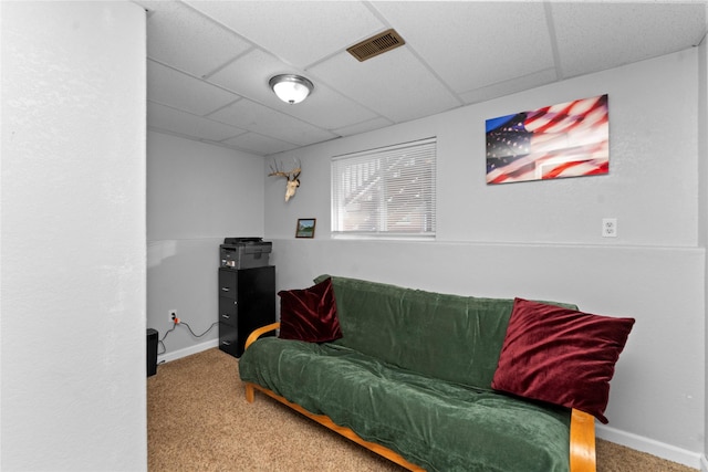 living room featuring a paneled ceiling and carpet