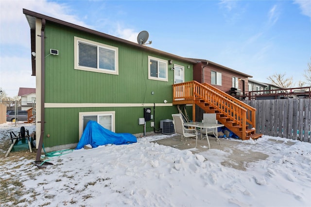 snow covered property with central AC