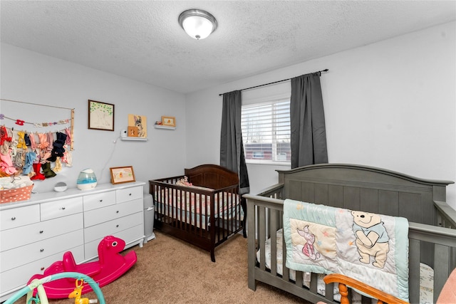 carpeted bedroom with a nursery area and a textured ceiling