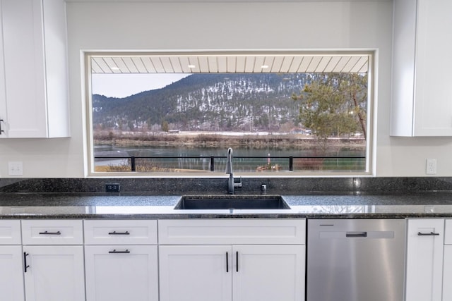 kitchen featuring a mountain view, sink, stainless steel dishwasher, and white cabinets